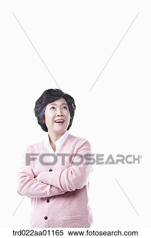 An elderly woman looking at the sky with her arms folded View Large Photo Image Stock Photography - An elderly woman looking at the sky with her arms folded. Fotosearch