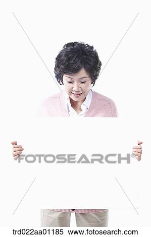 Stock Photography - An elderly woman looking down on a white board. Fotosearch