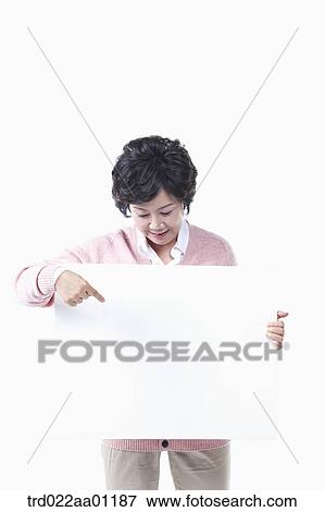 Stock Photo - An elderly woman pointing to a white board. Fotosearch