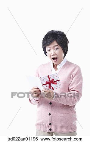 An elderly woman surprising at a card View Large Photo Image Stock Photograph - An elderly woman surprising at a card. Fotosearch