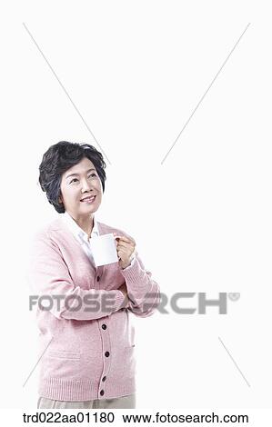 Stock Image - An elderly woman with a cup of coffee. Fotosearch