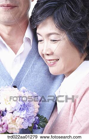 An elderly woman with an elderly man and a bouquet of flower View Large Photo Image Stock Photo - An elderly woman with an elderly man and a bouquet of flower. Fotosearch