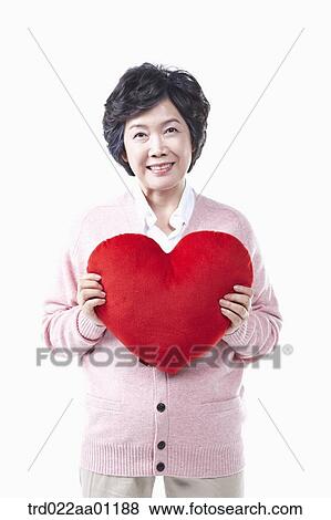 Stock Photo - An elderly woman with the red heart . Fotosearch