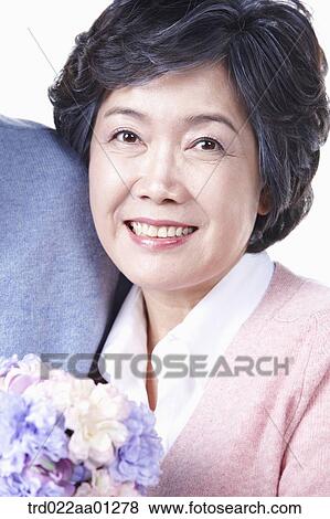 An smiling elderly woman with a bouquet of flower View Large Photo Image Stock Photo - An smiling elderly woman with a bouquet of flower. Fotosearch