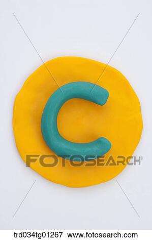 Stock Photo - The alphabet C shaped green clay on the yellow circle clay . Fotosearch