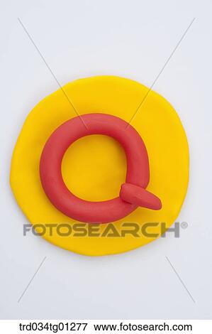 Stock Photo - The alphabet Q shaped red clay on the yellow circle clay . Fotosearch