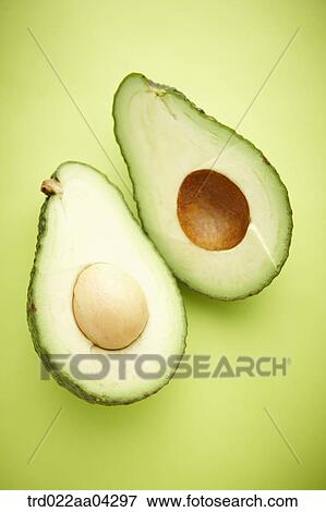 The avocado in half with the green background View Large Photo Image Stock Photo - The avocado in half with the green background. Fotosearch