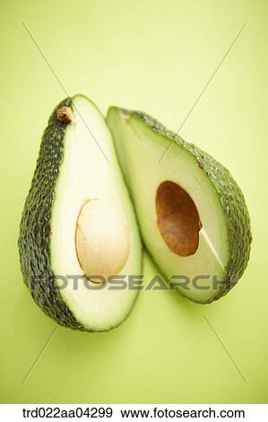 The avocado in half with the green background View Large Photo Image Stock Photo - The avocado in half with the green background. Fotosearch