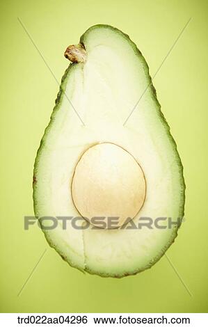 The avocado in half with the green background View Large Photo Image Stock Photograph - The avocado in half with the green background. Fotosearch