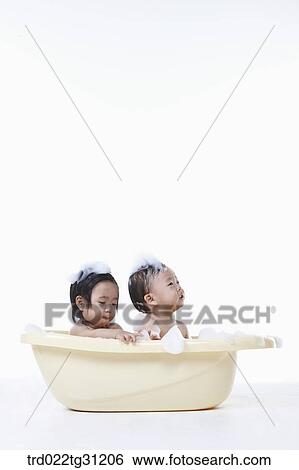 The babies taking a bath in the bathtub with the bubble on their bodies View Large Photo Image Stock Photograph - The babies taking a bath in the bathtub with the bubble on their bodies. Fotosearch