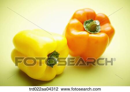 Stock Image - The colorful bell peppers with the green background. Fotosearch