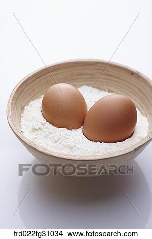 The eggs in the bowl of flour View Large Photo Image Picture - The eggs in the bowl of flour. Fotosearch