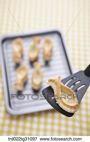 Stock Photo - The fish shaped cookie on the spatula. Fotosearch