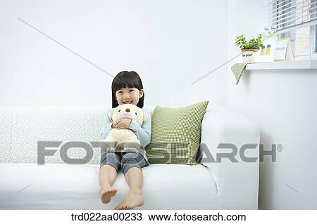 Stock Image - The girl hugging the teddy bear . Fotosearch