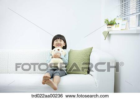 Stock Photograph - The girl hugging the teddy bear . Fotosearch