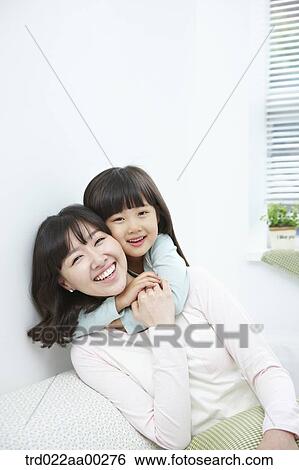 Stock Photograph - The girl hugging the woman from back. Fotosearch