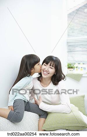 The girl kissing on woman's cheek View Large Photo Image Picture - The girl kissing on woman's cheek. Fotosearch
