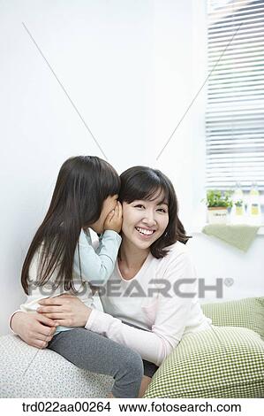 The girl whispering in woman's ear View Large Photo Image Picture - The girl whispering in woman's ear. Fotosearch
