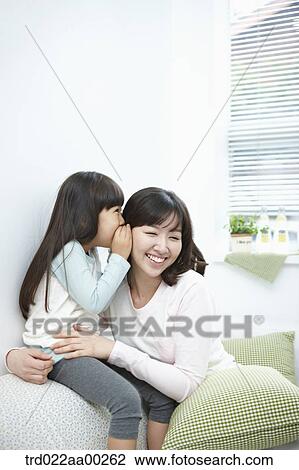 The girl whispering in woman's ear View Large Photo Image Stock Image - The girl whispering in woman's ear. Fotosearch