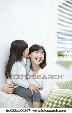The girl whispering in woman's ear View Large Photo Image Stock Photo - The girl whispering in woman's ear. Fotosearch