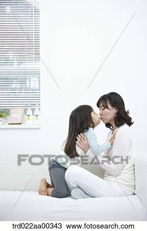 The kissing woman and girl on the couch View Large Photo Image Stock Image - The kissing woman and girl on the couch. Fotosearch