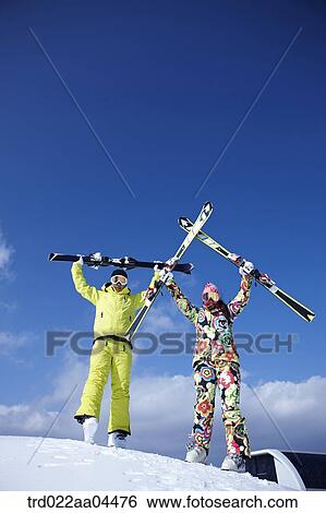 The man and woman holding up the ski gear View Large Photo Image Stock Photograph - The man and woman holding up the ski gear. Fotosearch