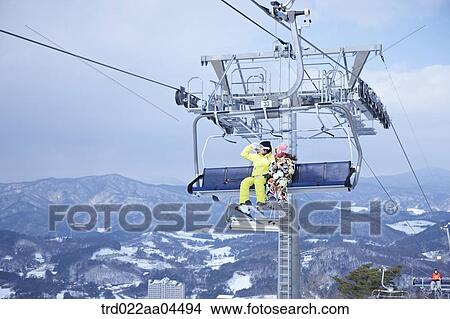The man and woman wearing the ski gear on the lift View Large Photo Image Picture - The man and woman wearing the ski gear on the lift . Fotosearch