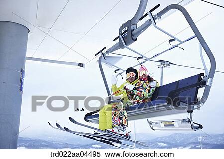 The man and woman wearing the ski gear on the lift View Large Photo Image Stock Photography - The man and woman wearing the ski gear on the lift . Fotosearch