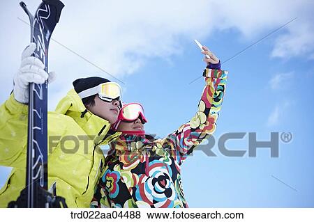 The man and woman wearing the ski wear taking picture together View Large Photo Image Stock Photo - The man and woman wearing the ski wear taking picture together. Fotosearch