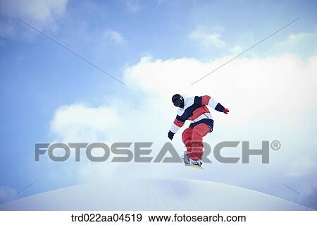 Stock Photo - The man jumping on the snowboard. Fotosearch
