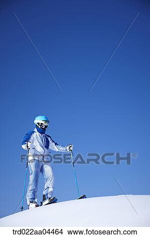 Picture - The man wearing skiwear and gear on the slope. Fotosearch
