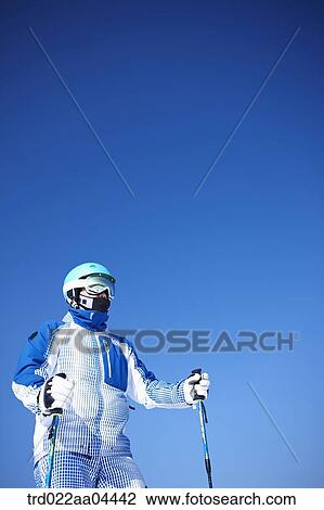 The man wearing skiwear with the ski poles View Large Photo Image Stock Image - The man wearing skiwear with the ski poles . Fotosearch