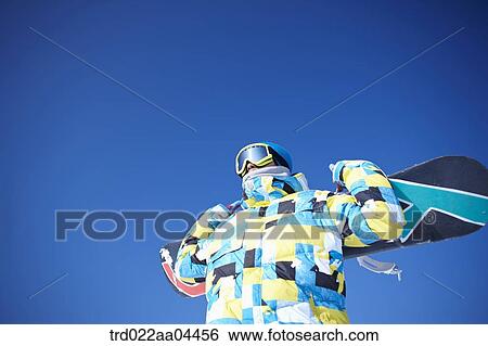 The man with the snowboard over his shoulders View Large Photo Image Stock Photograph - The man with the snowboard over his shoulders. Fotosearch