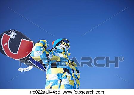 The man with the snowboard over his shoulders View Large Photo Image Stock Photography - The man with the snowboard over his shoulders. Fotosearch