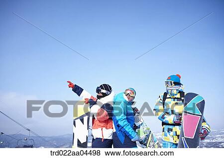 Stock Photo - The people wearing the snowboarding wear with the snowboard. Fotosearch