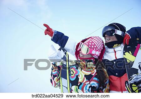 The people with the ski and snowboarding gear pointing out the sky View Large Photo Image Stock Photo - The people with the ski and snowboarding gear pointing out the sky. Fotosearch