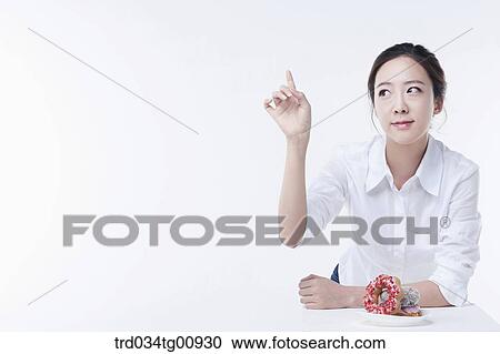 Stock Image - The pointing woman with the doughnuts. Fotosearch