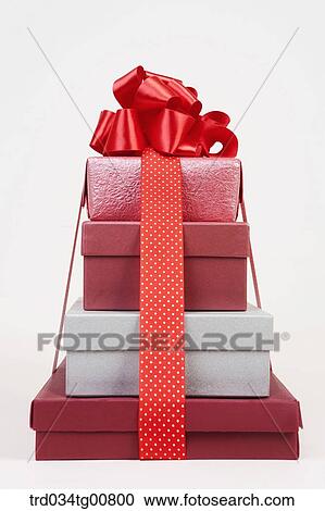Stock Image - The red and silver gift boxes with big red ribbon . Fotosearch