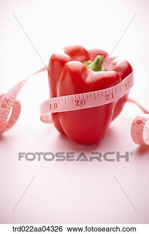 Stock Photograph - The red bell pepper tied with the tape measure. Fotosearch
