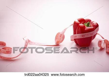 Stock Photography - The red bell pepper tied with the tape measure. Fotosearch