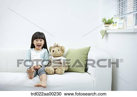 The smiling girl on the white couch View Large Photo Image Stock Image - The smiling girl on the white couch . Fotosearch