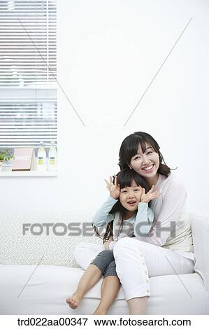 The smiling woman and girl on the couch View Large Photo Image Stock Photo - The smiling woman and girl on the couch. Fotosearch
