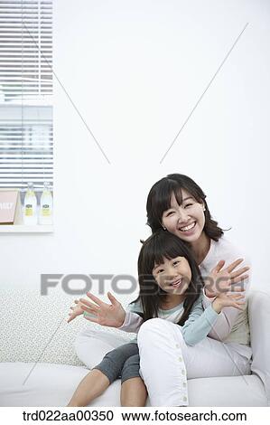Stock Image - The smiling woman and girl with their palms open. Fotosearch