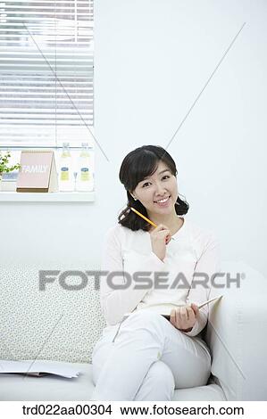 The smiling woman holding the pencil and notebook View Large Photo Image Picture - The smiling woman holding the pencil and notebook . Fotosearch