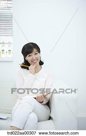 The smiling woman holding the pencil and notebook View Large Photo Image Stock Photo - The smiling woman holding the pencil and notebook . Fotosearch