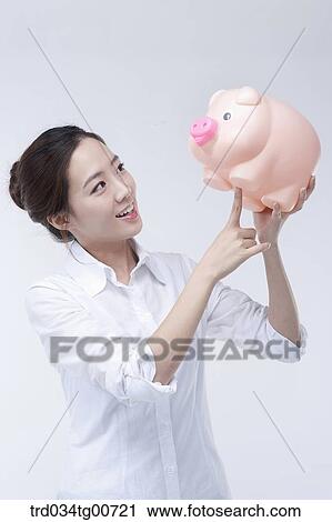 The smiling woman looking upon piggy bank View Large Photo Image Stock Image - The smiling woman looking upon piggy bank. Fotosearch