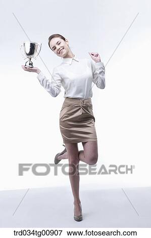 Stock Photo - The smiling woman with gold trophy. Fotosearch