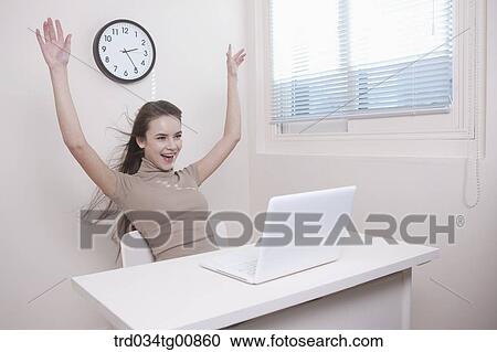 The smiling woman with her arms up in the office View Large Photo Image Stock Image - The smiling woman with her arms up in the office. Fotosearch