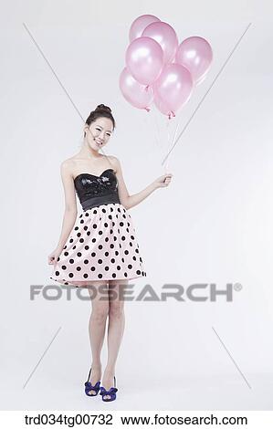 Stock Image - The smiling woman with pink balloons. Fotosearch