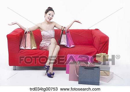 Stock Image - The smiling woman with shopping bags and boxes. Fotosearch